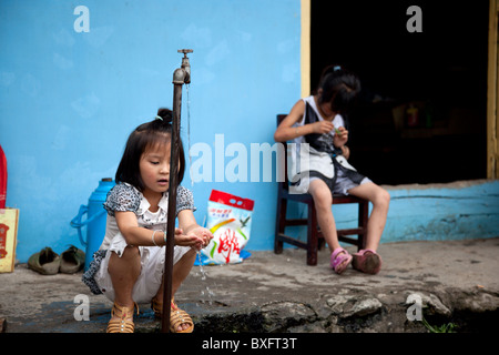 Una famiglia locale al di fuori della loro casa in Li Zhi Ba, un villaggio di Bai Shui Jiang, una riserva naturale in provincia di Gansu in Cina. Foto Stock