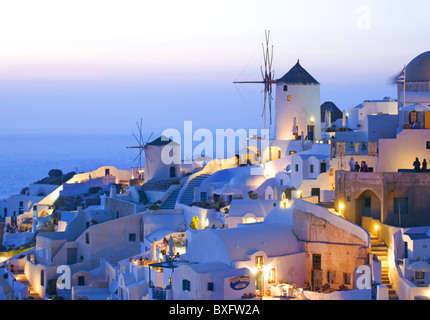 La cittadina di Oia Santorini con mulini a vento al tramonto Foto Stock