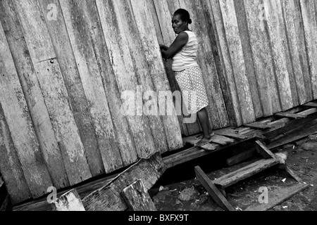 Una donna di sfollati entra nella sua casa in legno in stilt villaggio vicino a Tumaco, nariño dept., Colombia. Foto Stock