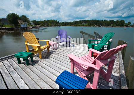 Nova Scotia, Canada. Sedie Adirondack sul molo intorno a Blue Rocks nel porto di Lunenburg. Foto Stock