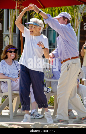 Un uomo nella sua severnties e una donna nel suo ballo degli anni ottanta insieme in corrispondenza di una fascia esterna in concerto a Coronado CA Foto Stock