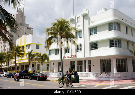 Coppia giovane condividendo una bicicletta da The Carlyle su Ocean Drive e South Beach, Miami, Florida, Stati Uniti d'America Foto Stock