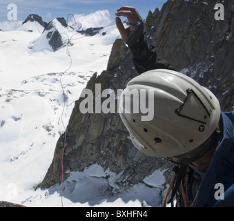 Un maschio di rocciatore si prepara a rappel giù dalla Pyramide du Tacul vicino a Mont Blanc in Chamonix, Francia. Foto Stock