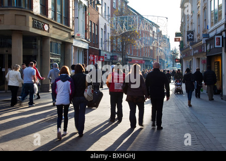 Negozi al dettaglio affollati con People Christmas Shopping strade affollate con negozi di moda urbana a Nottingham City Centre, High Street, Regno Unito Foto Stock