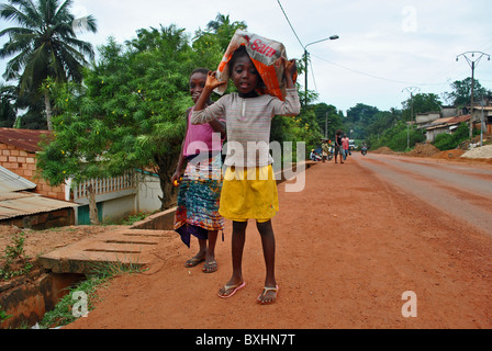 Ragazza giovane portano carichi pesanti in Sassandra, Costa d Avorio, Africa occidentale Foto Stock