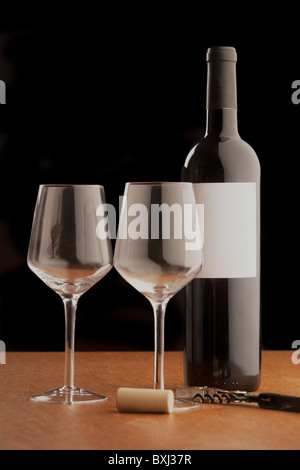Due bicchieri di vino accanto a prodotti senza marchio bottiglia di vino rosso con il sughero e un cavatappi. Foto Stock