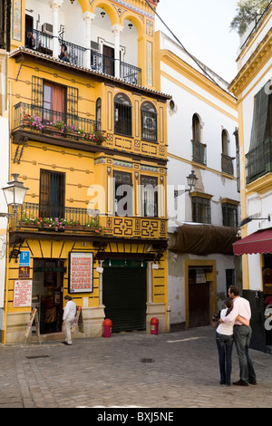 Coppia di fronte a un piccolo ristorante - Restaurante Monreal - / hotel con il chitarrista / chitarrista sul balcone. Siviglia. Spagna. Foto Stock