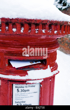 Invio di lettere / Carte di Natale in un red letter box coperti di neve. Regno Unito Foto Stock