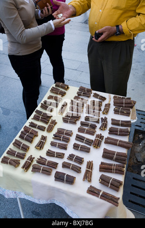 Persone /persona che paga / acquisto di materie naturali bastoncini di liquirizia / liquirizia stick da street / Fornitore / Mercato in stallo. Siviglia. Spagna Foto Stock