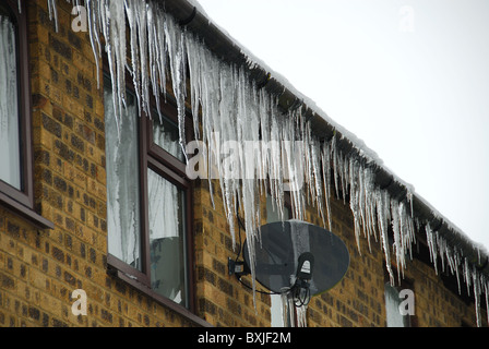 Un sacco di grandi ghiaccioli appesi da una gronda del tetto. Regno Unito, dicembre 2010. Foto Stock