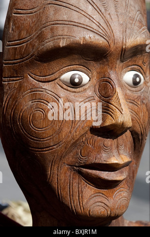 Un legno intagliato maschera Maori con tatuaggi tradizionali Foto Stock