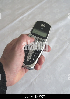 L'uomo la composizione di un numero su un Binatone Telefono Cordless modello rilasciato Foto Stock