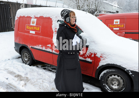 Donna post raccolta dall'ufficio di smistamento a Telford dove le consegne postali sono state cancellate a causa delle condizioni meteorologiche Foto Stock