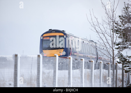 Local commuter train service in esecuzione nel paesaggio invernale Montrose costa orientale della Scozia. Foto Stock