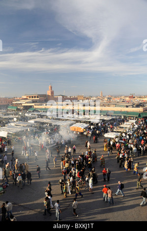 Vista generale della trafficata Djemaa el Fna luogo di incontro con stand gastronomici e fumo Foto Stock
