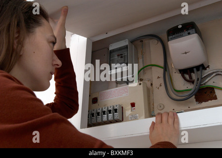 Donna controllo del contatore di energia elettrica, REGNO UNITO Foto Stock