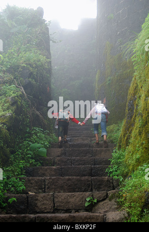 Due bambine a salire le scale di fort Purndar, Distretto di Pune, Maharashtra. Foto Stock