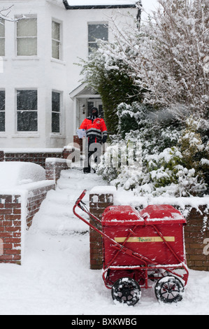 Un postino consegnare le lettere durante una tempesta di neve nel sud di Londra Foto Stock