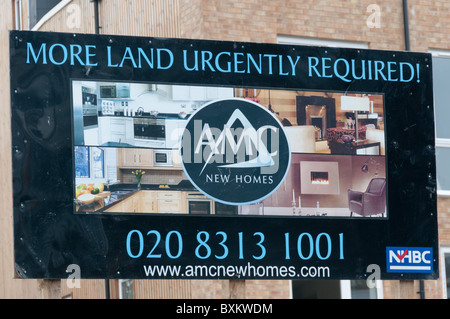 Un cartello che diceva "più terra richiesto urgentemente!' su un edificio residenziale sito nella parte sud di Londra. Foto Stock