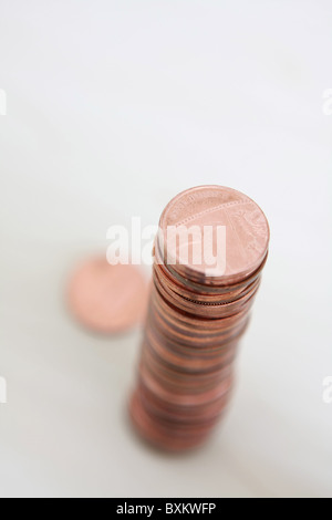 Una pila di sterling 1p monete visto da sopra con un fuori fuoco coin allentato dalla pila Foto Stock