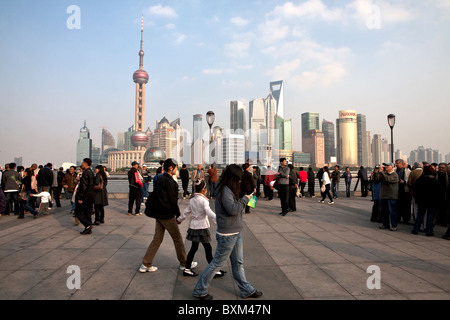 Persone in piedi al Bund lungomare con vista di Pudong in background, Shanghai, Cina Foto Stock