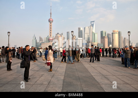 Persone in piedi al Bund lungomare con vista di Pudong in background, Shanghai, Cina Foto Stock