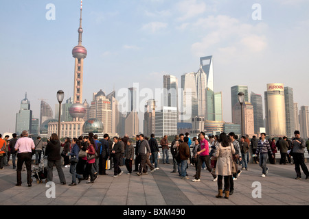 Persone in piedi al Bund Promenade con vista di Pudong sullo sfondo, Shanghai, Cina Foto Stock