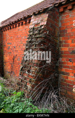 In mattoni rossi fattoria, stalla,stabile etc. Vecchio edificio, che necessitano di un sostegno supplementare per mantenere le pareti, inserire il contrafforte's Foto Stock