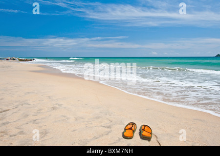 Paio di pantofole su una solitaria spiaggia di Nilaveli, Trincomalee, Sri Lanka East Coast. Foto Stock