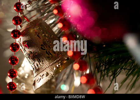 Il Natale e il nuovo anno celebrazione catene colorate campane e giocattoli appendere su albero di Natale Foto Stock