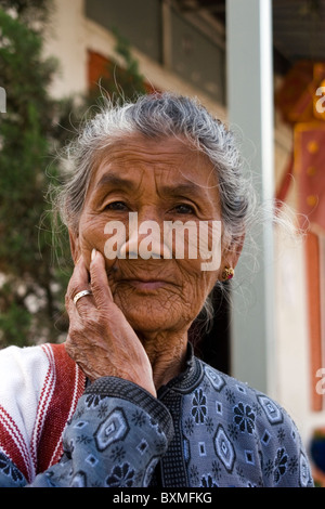 Un'anziana donna asiatica che indossa un maglione blu è in posa per un ritratto a Mae Sariang, Thailandia. Foto Stock