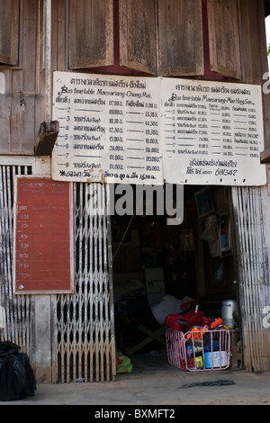 Un segno con un bus schedule annuncia gli orari di partenza per Chiang Mai al Mae Sariang alla stazione degli autobus in Thailandia. Foto Stock