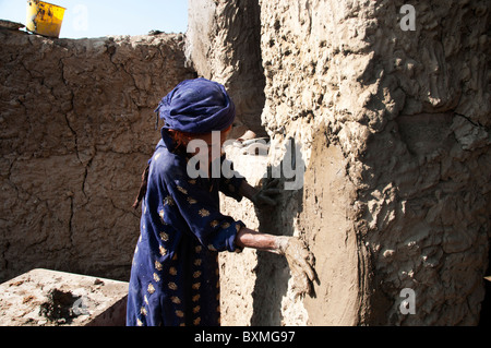 Kheshgi camp per i rifugiati afghani. Dopo il diluvio. 76 anni Khalthoum Safk cerotti la sua casa ricostruita con fango. Foto Stock