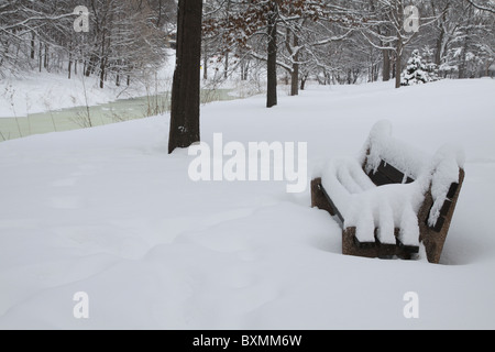 Una coperta di neve una panchina nel parco di Minneapolis, Minnesota Foto Stock