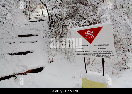 Un segno, in albanese e serbo, avverte della presenza di mine antiuomo in Germia Park, un area pubblica fuori Pristina in Kosovo Foto Stock