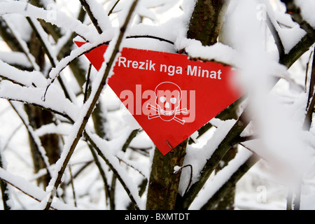 Un segno di avvertimento albanese della presenza di mine antiuomo in Germia Park, un area pubblica fuori Pristina in Kosovo Foto Stock