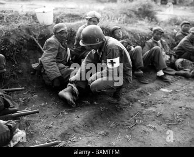 Guardando oltre i feriti Sgt Harold B. Vaughn 24 med bn 24 Stati Uniti fanteria guarda i piedi gonfi di un cinese Foto Stock