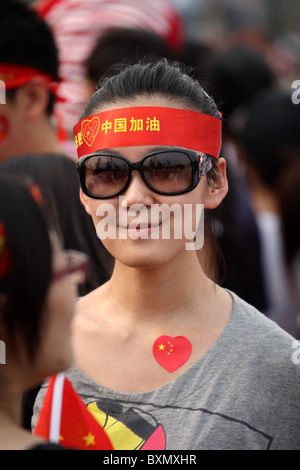 Chinese femmina che guarda la Parata dei Giochi pre-olimpici, Pechino, Cina Foto Stock