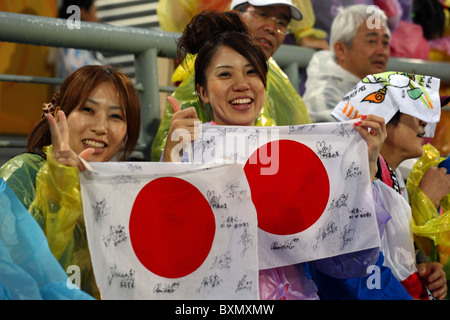 Due femmine giapponese mantenendo la bandiera nazionale autografate dai giocatori dei signori Field Hockey team, Giochi Olimpici di Pechino Foto Stock