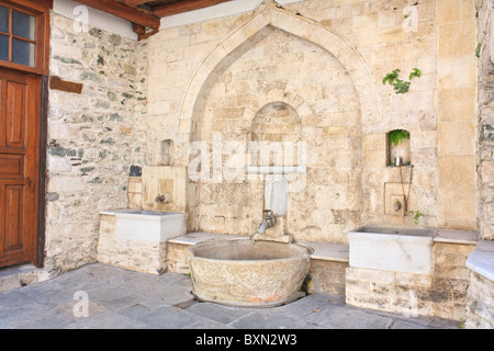 Decorativi in pietra bacino d'acqua e il rubinetto sul Monte Athos Foto Stock