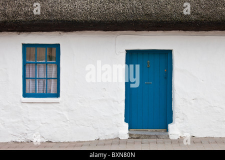 Blu e bianco tradizionale imbiancato cottage con tetto in paglia in Ardmore villaggio, nella contea di Waterford, Irlanda Foto Stock