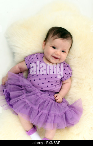 Infant Baby girl in studio di posa sul retro Foto Stock