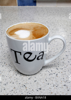 Tazza di caffè bere il caffè con il latte con la schiuma in Cina una tazza di tè con scritto su di esso sul piano di lavoro della cucina. Confusa identità Foto Stock