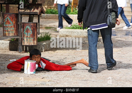 Giovane mendicante cinese con polio in strada, Lijiang, Yunnan, Cina Foto Stock