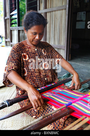 Donna tessitura tradizionalmente tais dorsalino sul telaio nel Timor Orientale Foto Stock