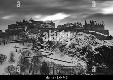 Il Castello di Edimburgo con un inverno a copertura di neve fresca contro un cielo drammatico Foto Stock