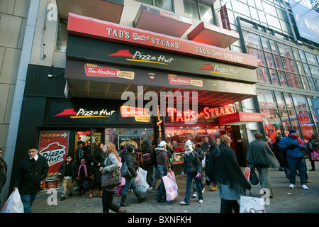 Un assortimento di fast food franchising situati in uno storefront in Midtown Manhattan a New York Foto Stock