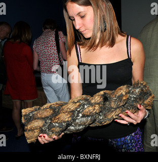 Visitatore tenendo un campione di conserve di corda dal relitto della Mary Rose Museum. Portsmouth, Hampshire, Inghilterra, Regno Unito Foto Stock