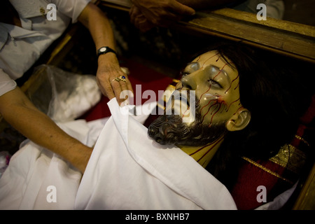 Le donne sfregano olio su una statua di Gesù Cristo dopo una settimana Santa processione in Oaxaca, Messico, 11 aprile 2009. Foto Stock