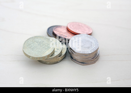 Alcuni sterling 2p e 1p monete dietro due pile di £ 1 e 20p delle monete in euro Foto Stock